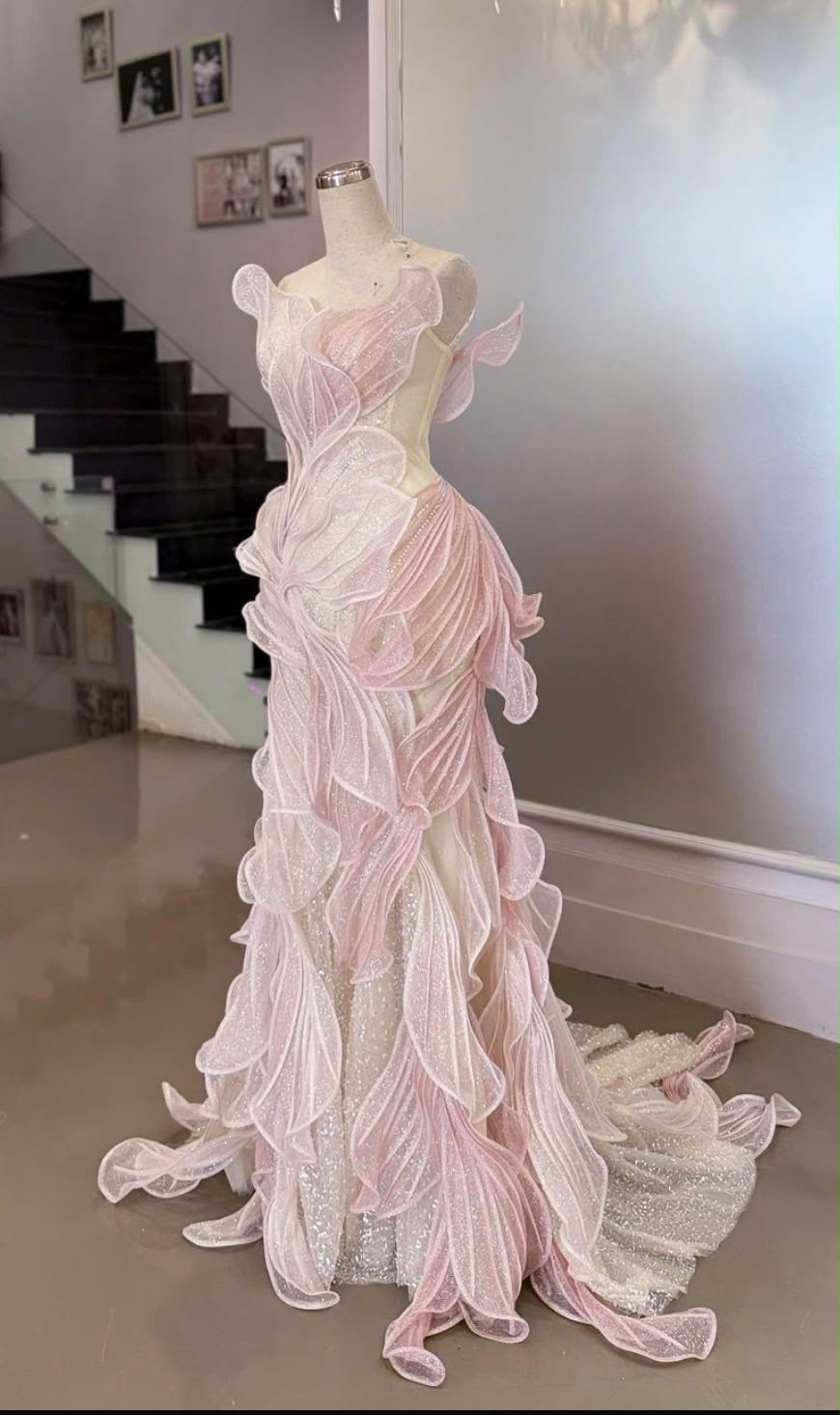 Full-length blush-pink petal gown on a mannequin